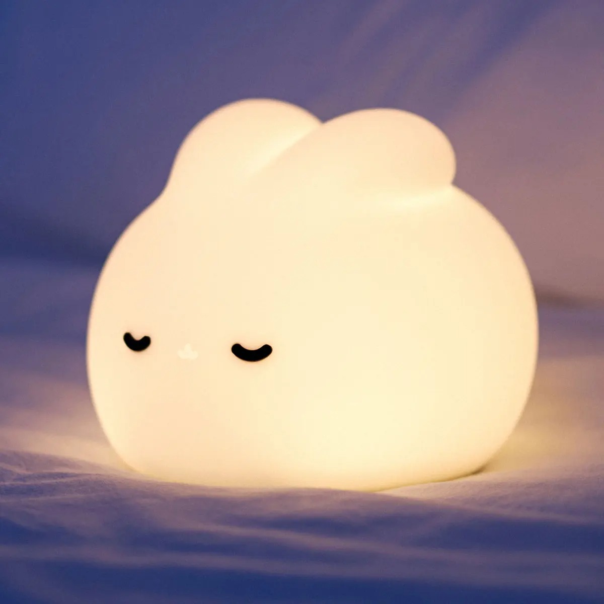 Sleepy bunny night light with warm glow illuminating a room